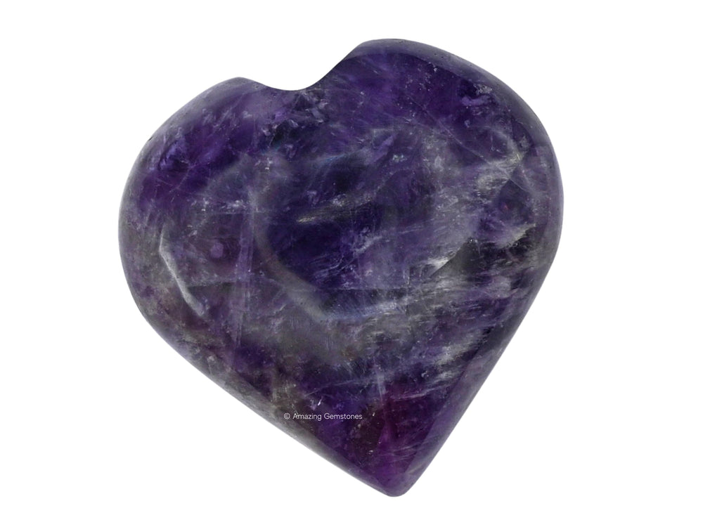 Amazing Gemstone amethyst heart palm stone glows softly beside crystal grids in a calm space.