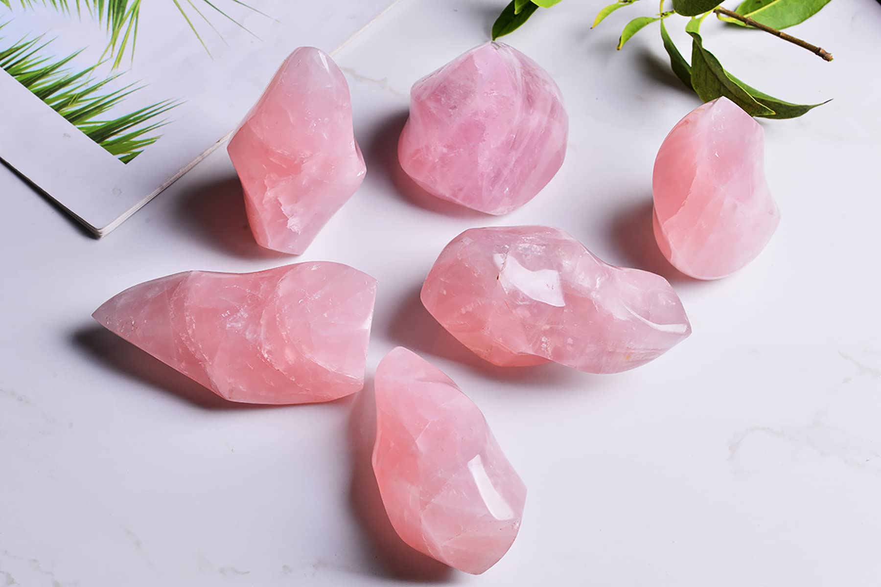 AMOYSTONE Rose Quartz Flame Tower, shown on a coffee table, adds calming charm to home decor.