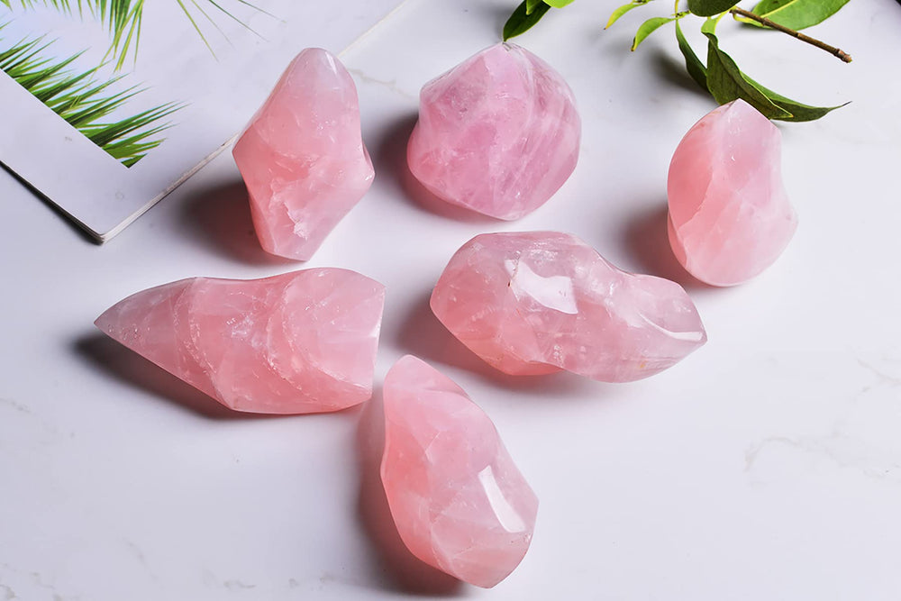 AMOYSTONE Rose Quartz Flame Tower, shown on a coffee table, adds calming charm to home decor.