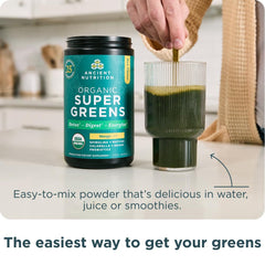 Ancient Nutrition SuperGreens scoop beside glass of prepared mango shake.
