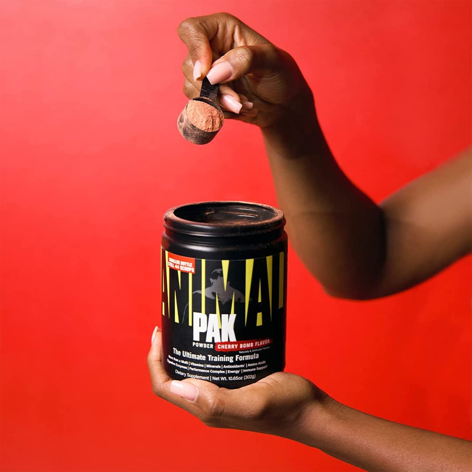 Animal Pak packets beside a glass of water for daily use.