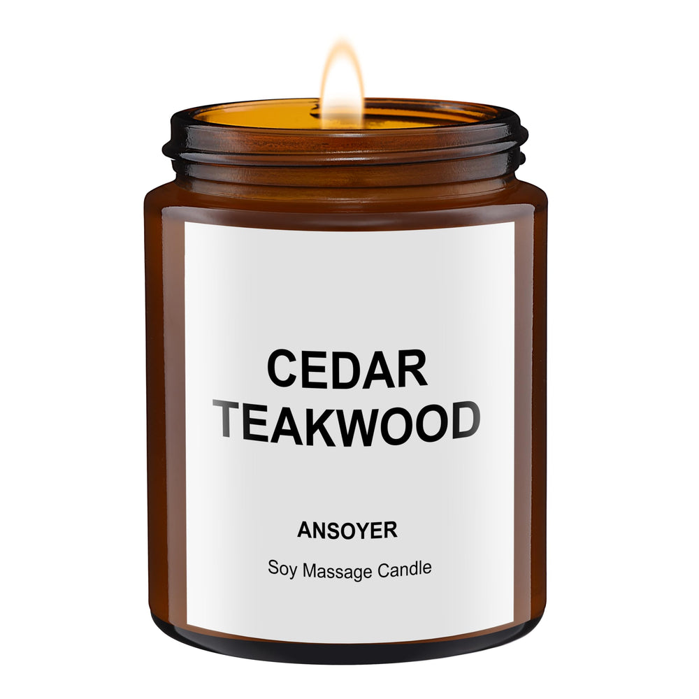 ANSOYER massage oil candle cedar-teakwood lit for warm relaxation.
