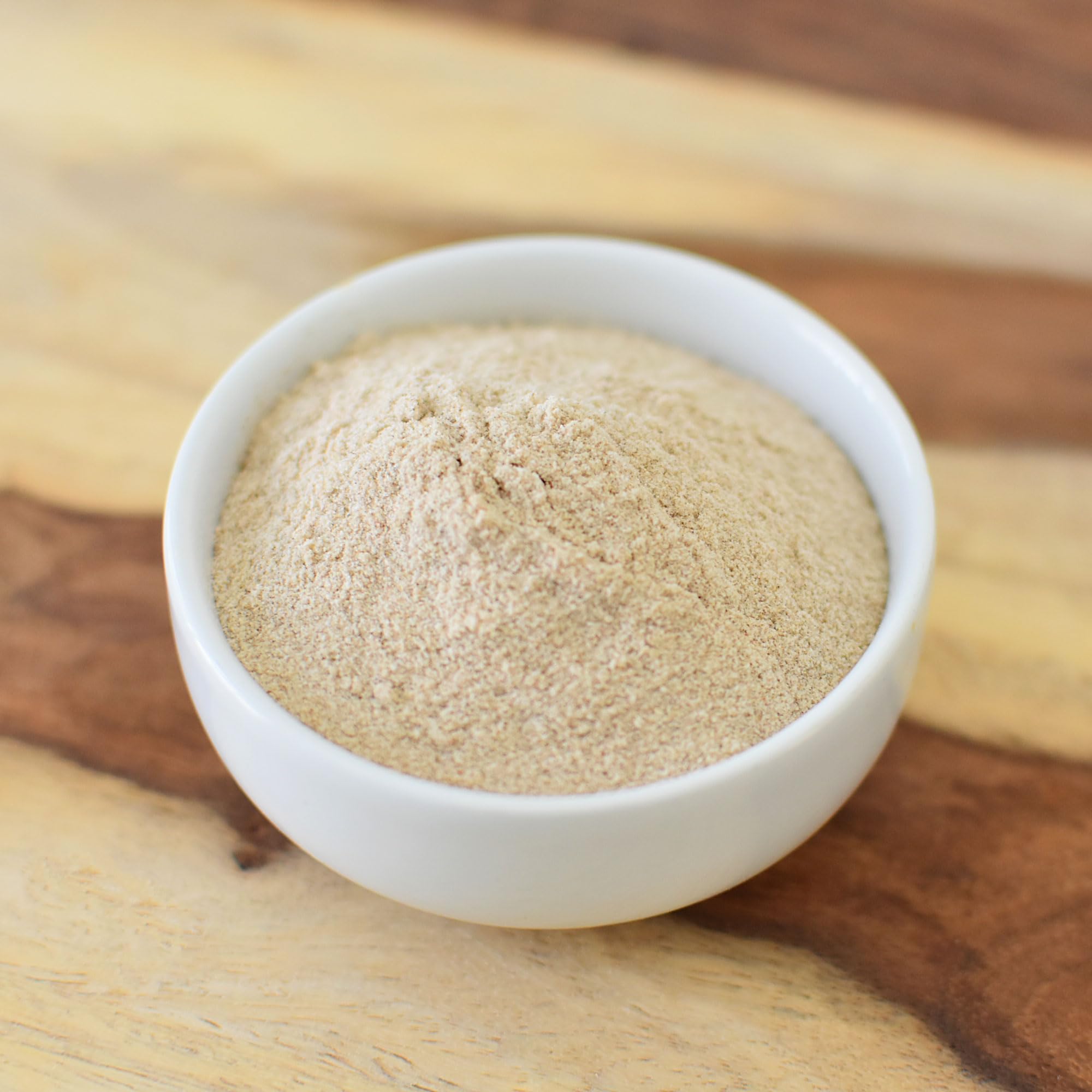 Glass jar of Anthony's Organic Psyllium Husk Powder on a clean kitchen counter.