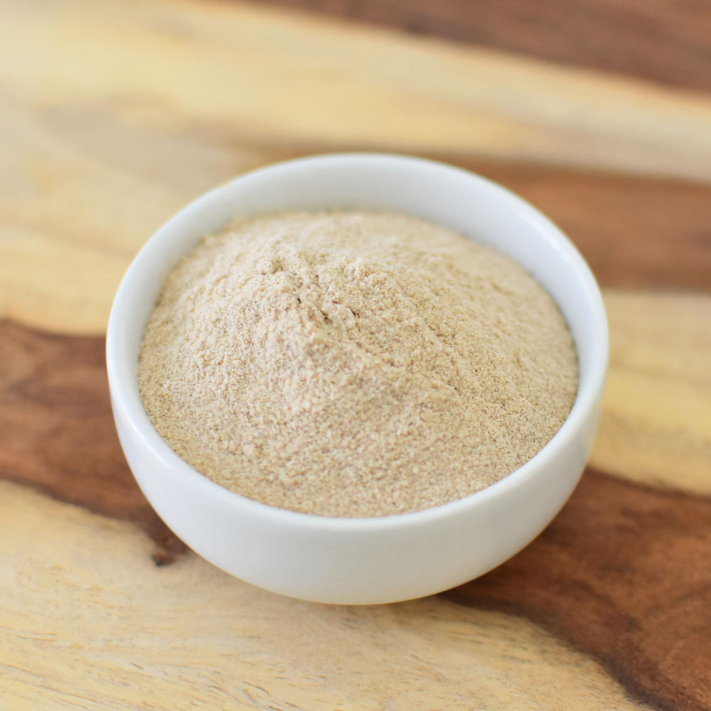 Glass jar of Anthony's Organic Psyllium Husk Powder on a clean kitchen counter.