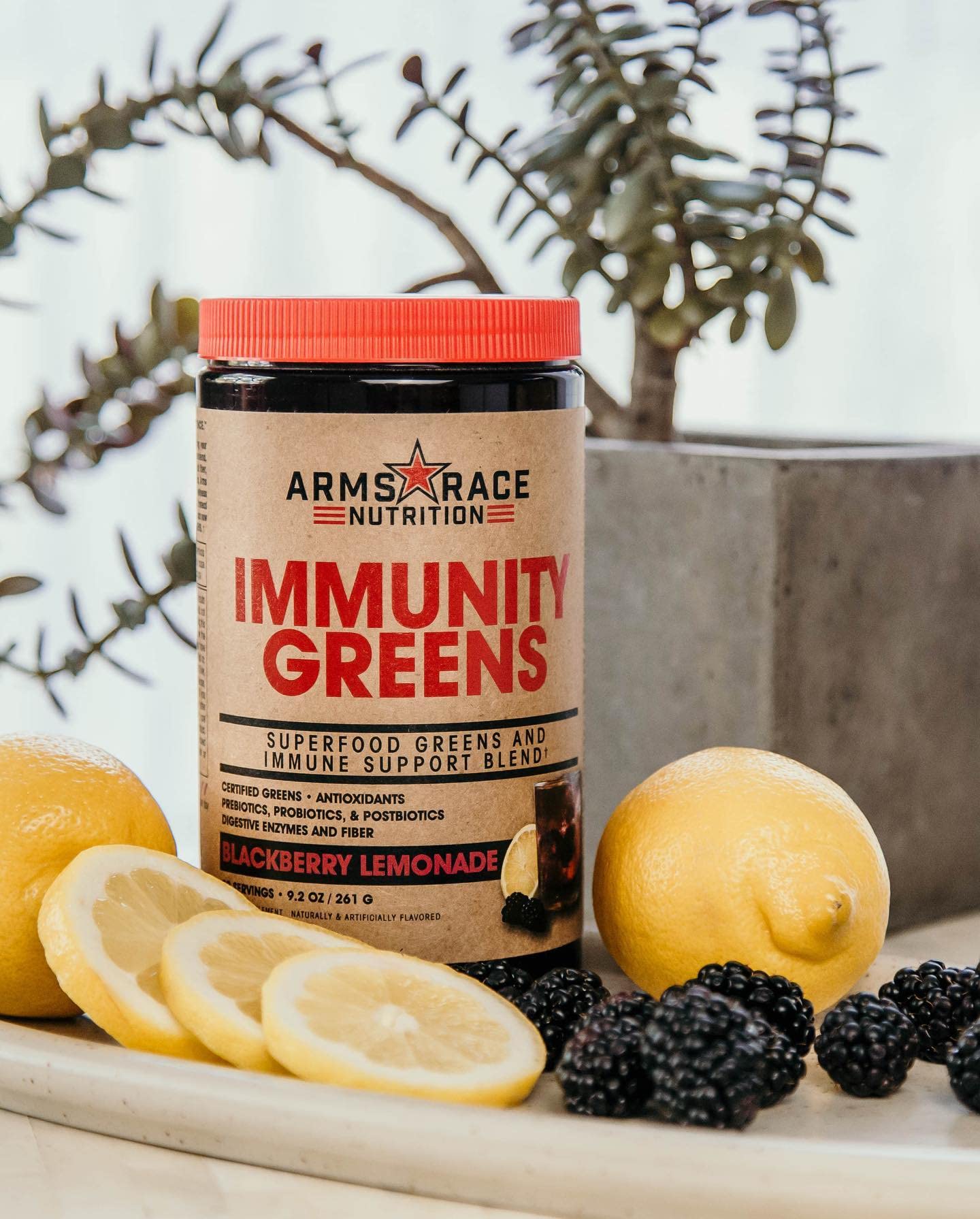 Arms Race Immunity Greens scoop beside bottle for convenient daily greens