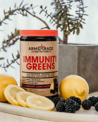 Arms Race Immunity Greens scoop beside bottle for convenient daily greens