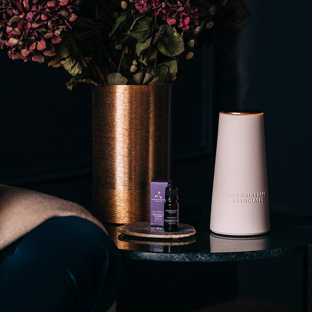 Aromatherapy Associates device in boost and standard modes dispersing aroma across a living area.