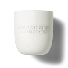 Aromatherapy Associates De-Stress Candle lit in a cozy room for focus.