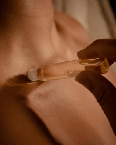 Aromatherapy Associates De-Stress Mind Rollerball roll-on being applied to wrists for relaxation.