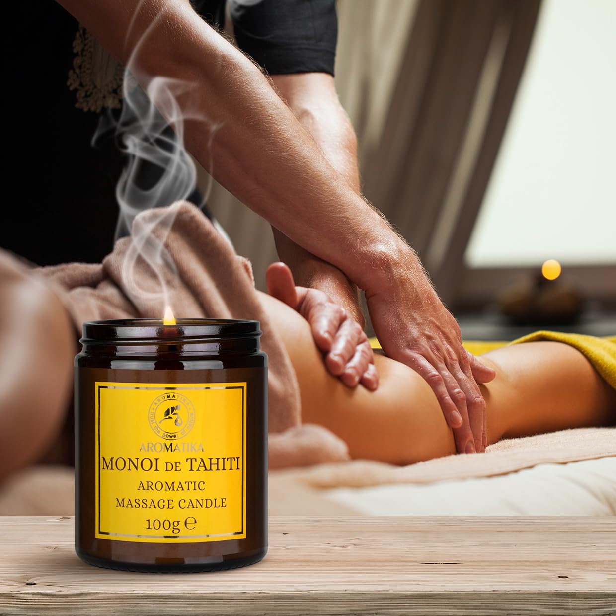 AROMATIKA Monoi Tahiti oils bottle beside candle evokes tropical relaxation.