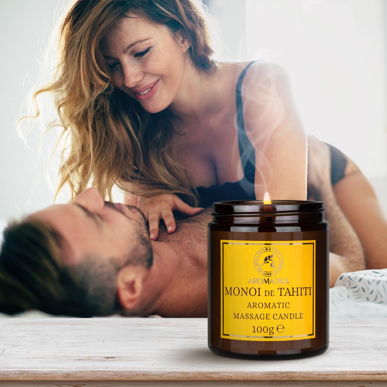 AROMATIKA 3.5oz candle close-up reveals creamy massage oil ready for skin care.