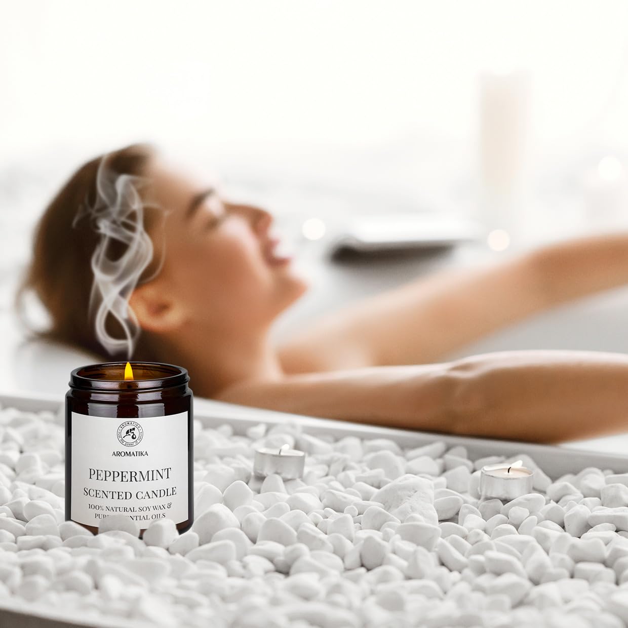 AROMATIKA peppermint candle on wood table, cozy natural setting.