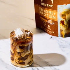 Ascent protein coffee powder being mixed with milk for smooth shakes.