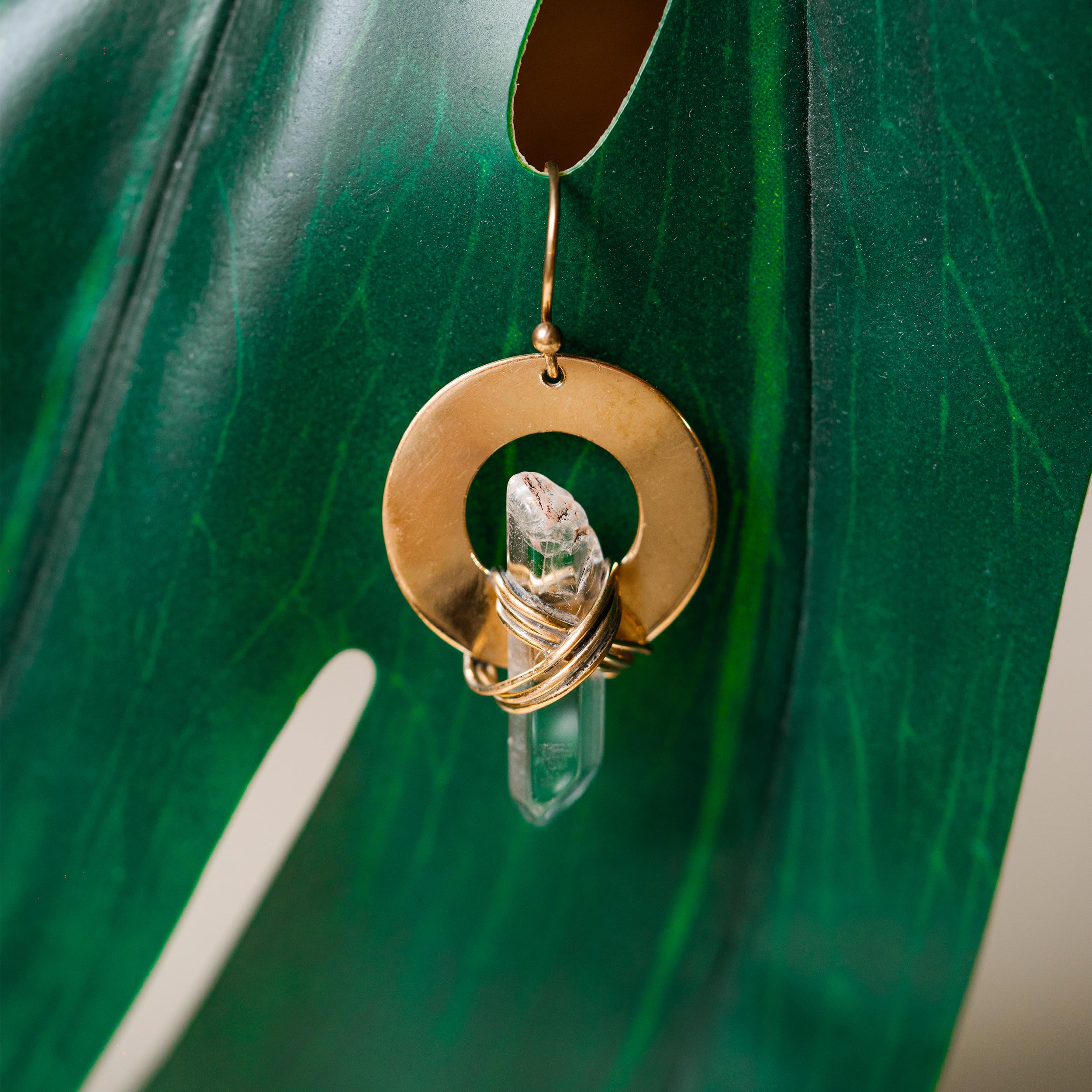 Ayana Crystals close-up of golden wrap on clear quartz earring.
