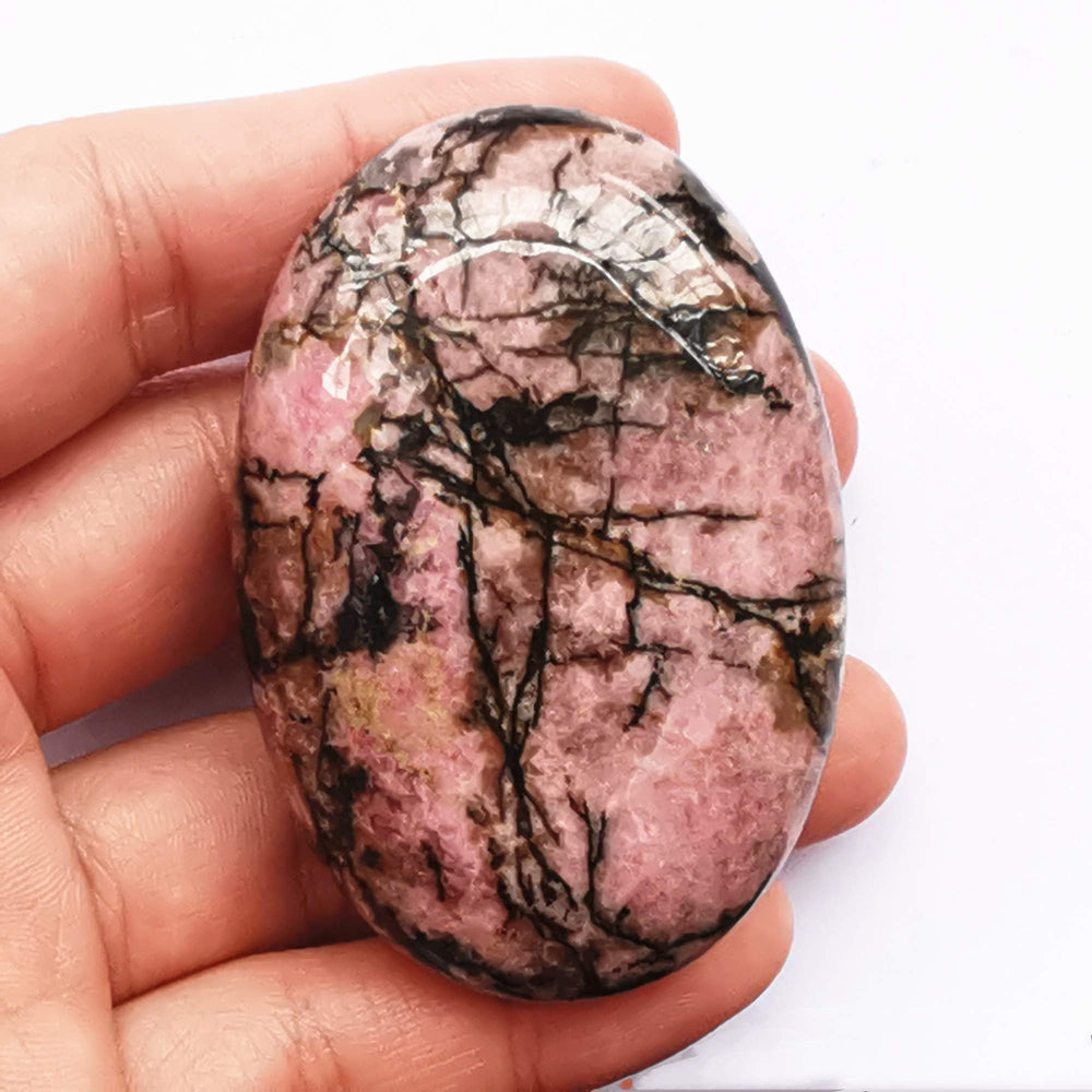 Close-up of Bacatgem rhodonite oval palm stone for soothing massage.