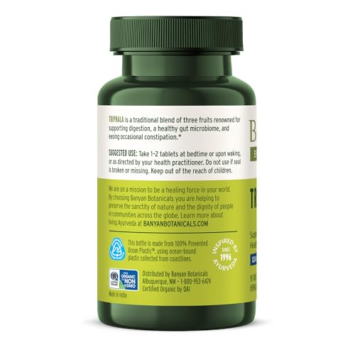 Banyan Botanicals Triphala daily routine setup with a glass of water.