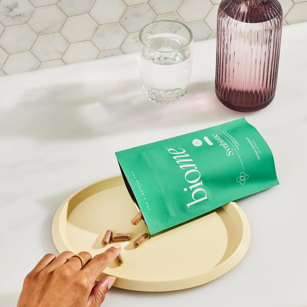 Biome Synbiotic capsules in hand illustrate on-the-go digestive support.
