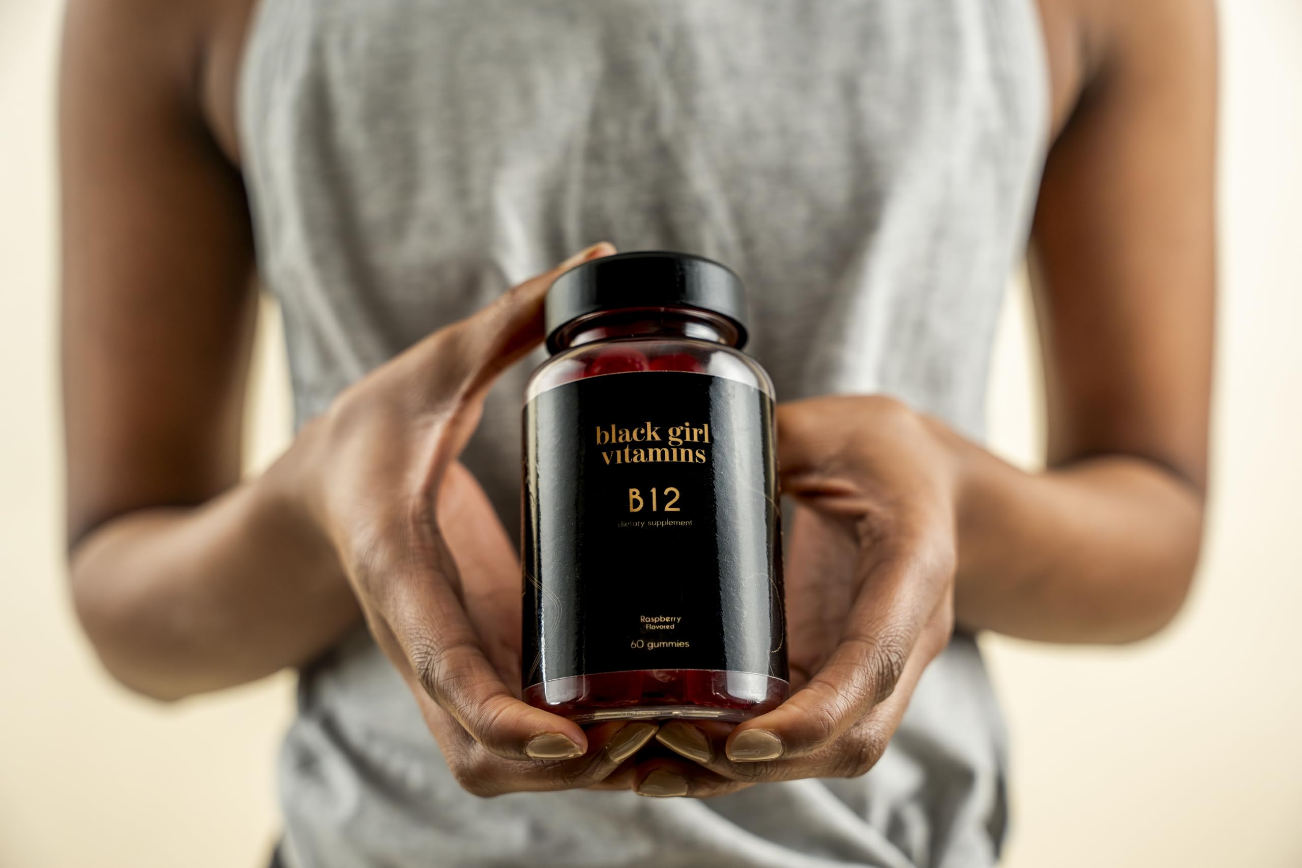 User taking a raspberry B12 gummy for daily energy with Black Girl Vitamins.
