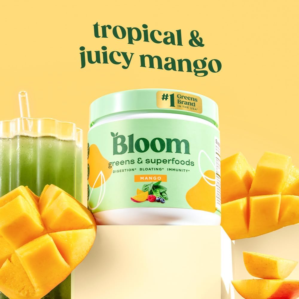 Chilled glass with greens powder and fresh mango slices on the counter.