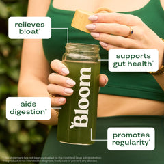 Scoop of Bloom Nutrition greens powder poured into a glass.