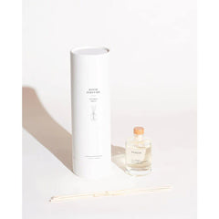 Close-up of the Santorini diffuser glass bottle with wooden stopper and eight reeds