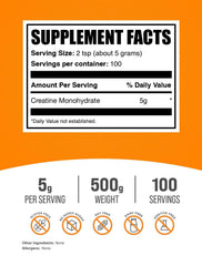 BulkSupplements Creatine Monohydrate Scoop beside glass for precise 5g servings