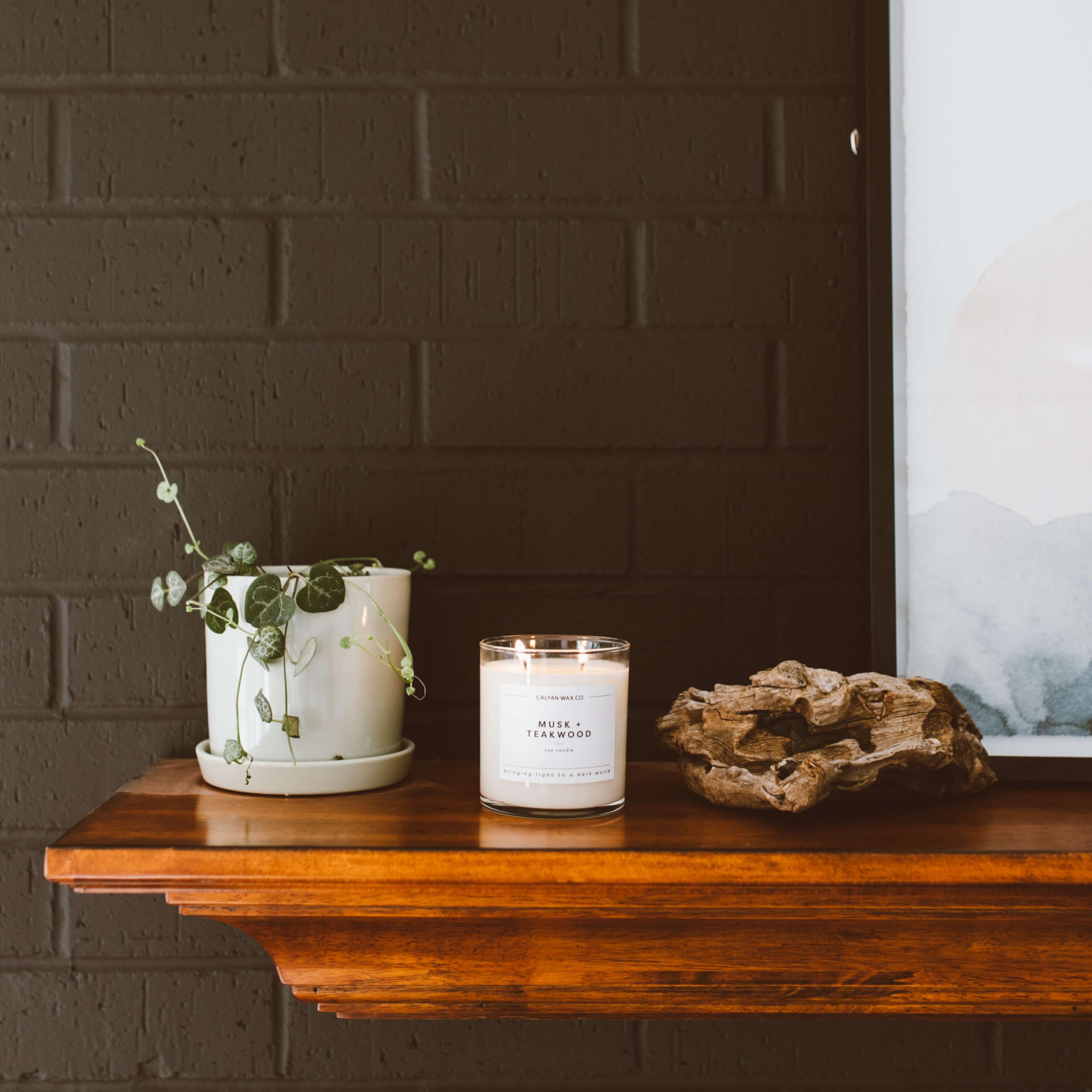Calyan Wax Co. Musk & Teakwood candle glow in a cozy living room