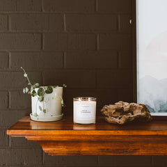 Calyan Wax Co. Musk & Teakwood candle glow in a cozy living room