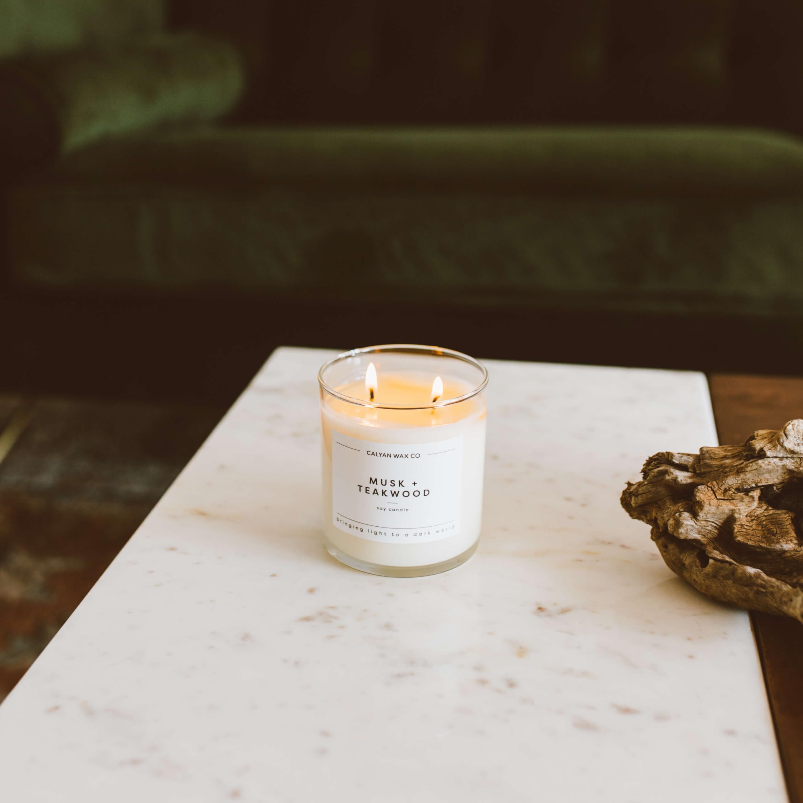 Calyan Wax Co. Musk & Teakwood jar on a coffee table