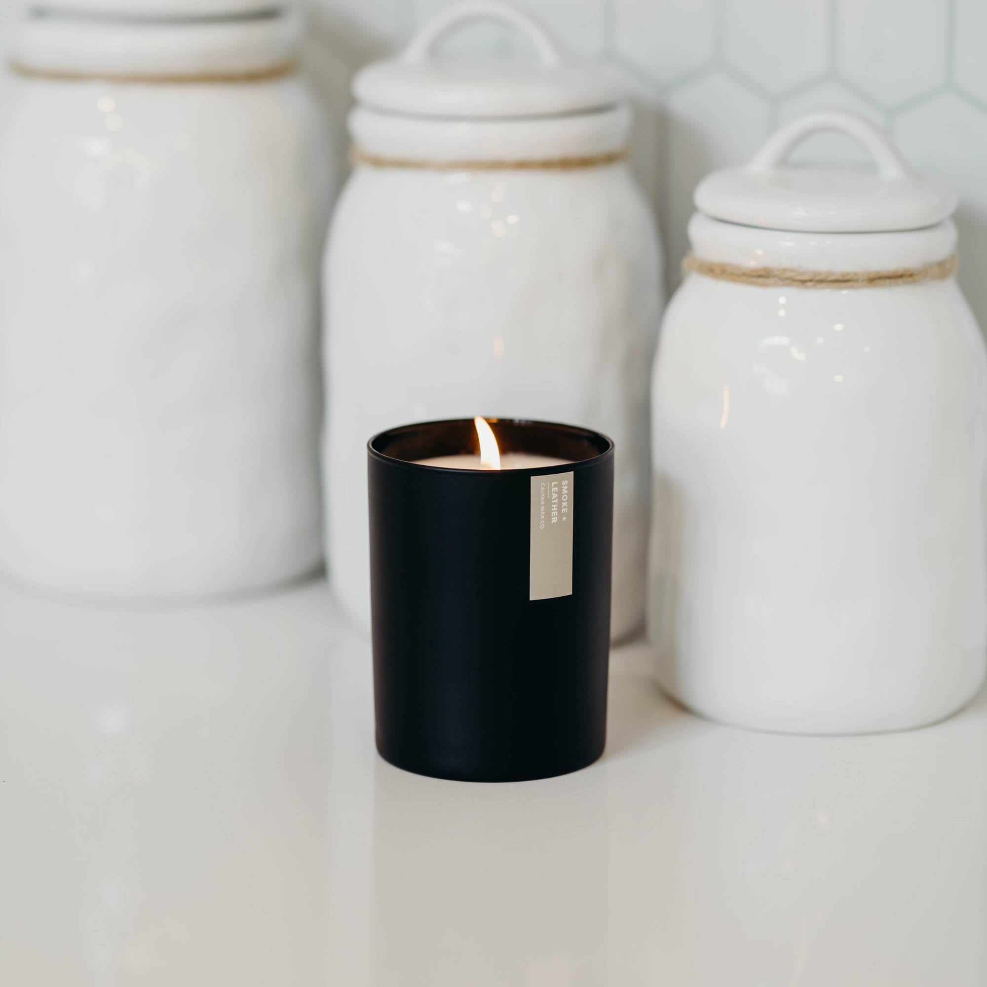 Calyan Wax Co. Smoke & Leather candle with 75-hour burn imagery in home setting.