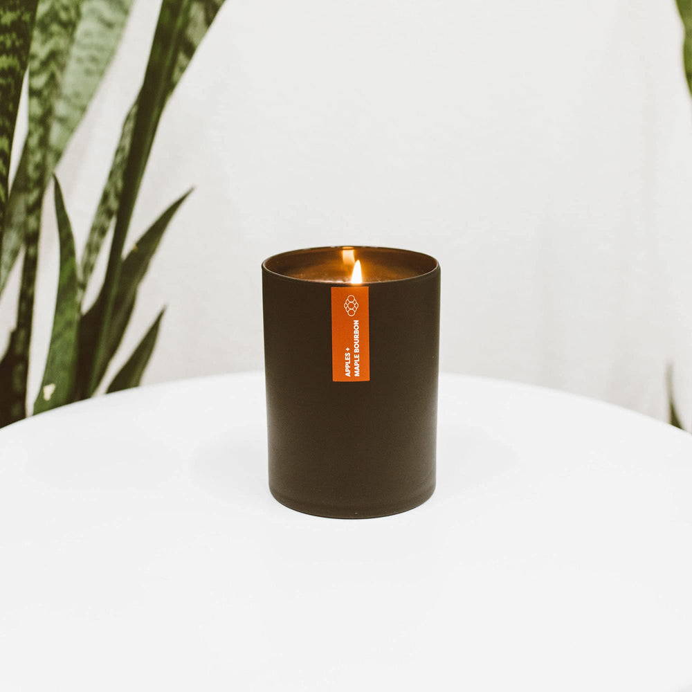 Calyan Wax Co. Apples and Maple Bourbon candle lit in a living room setting.