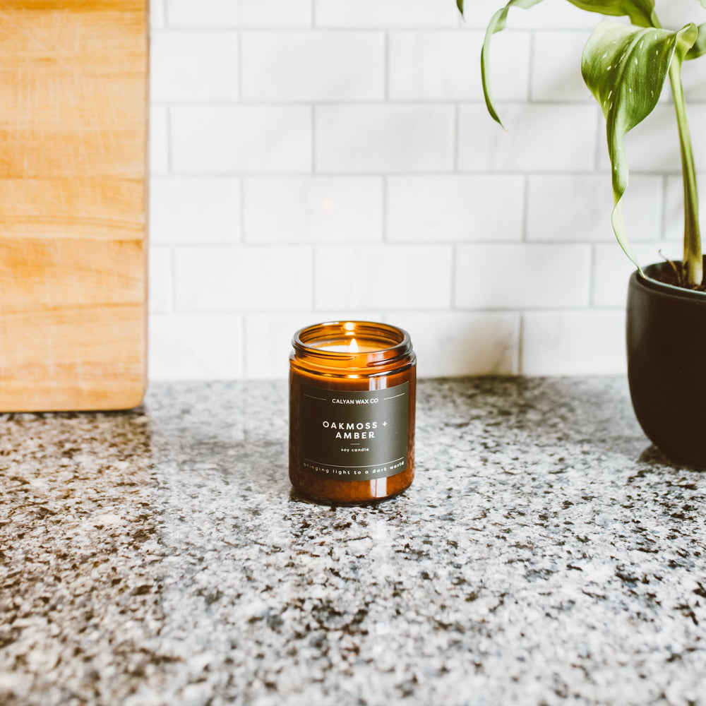 Calyan Aspen & Fog lit in amber jar evokes pine and cedar warmth