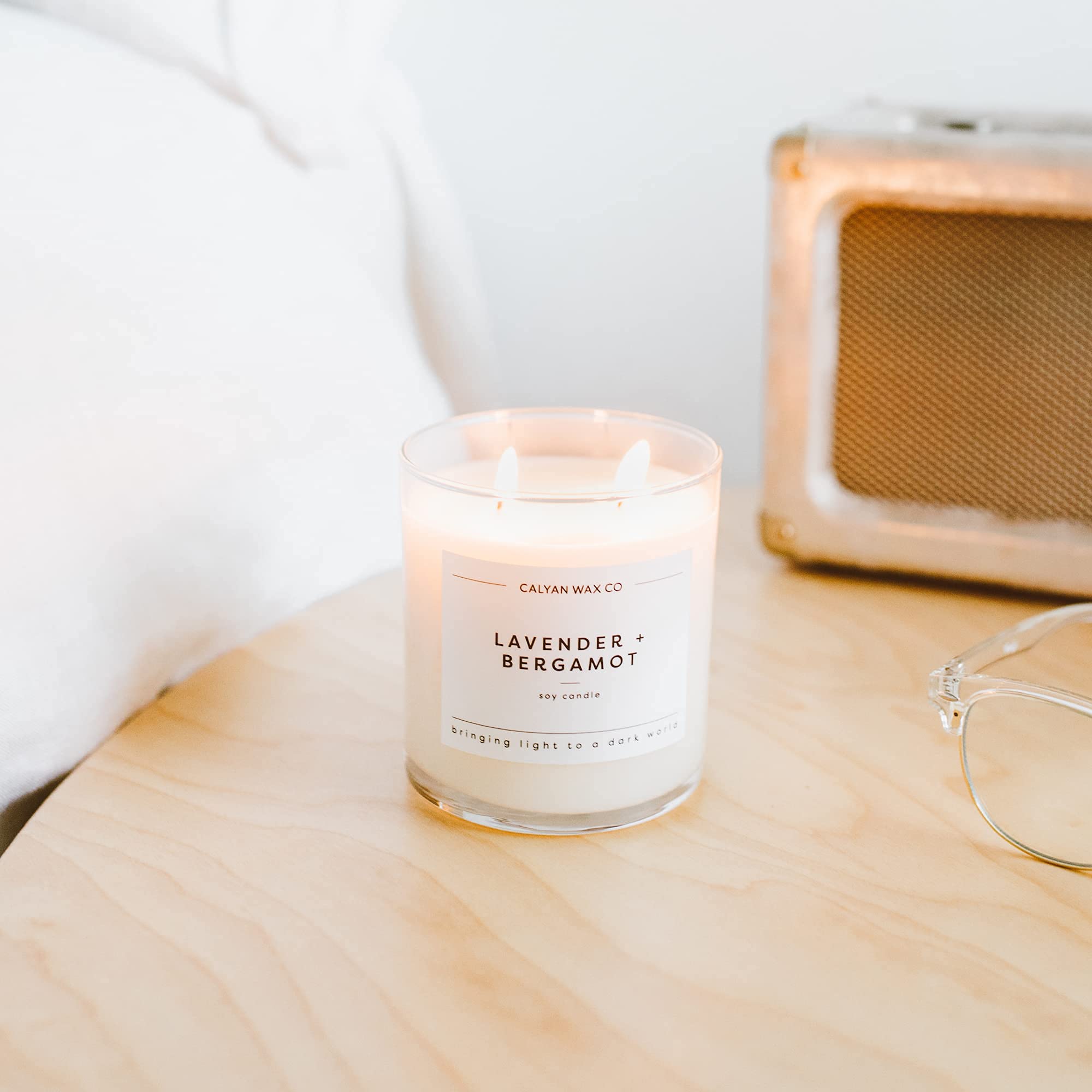 Calyan Wax Co. candle lit with warm dusk glow.