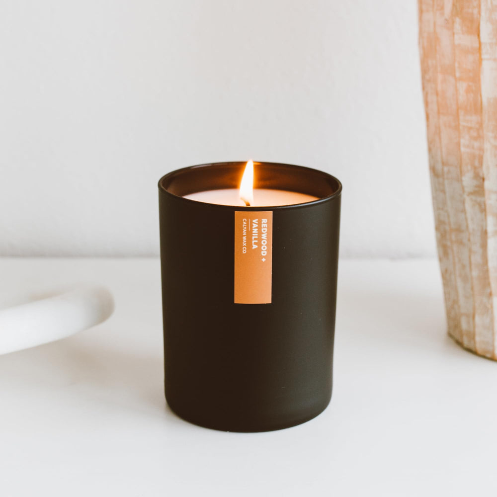 Calyan Wax Co. Redwood & Vanilla candle close-up shows warm amber and sandalwood depth.