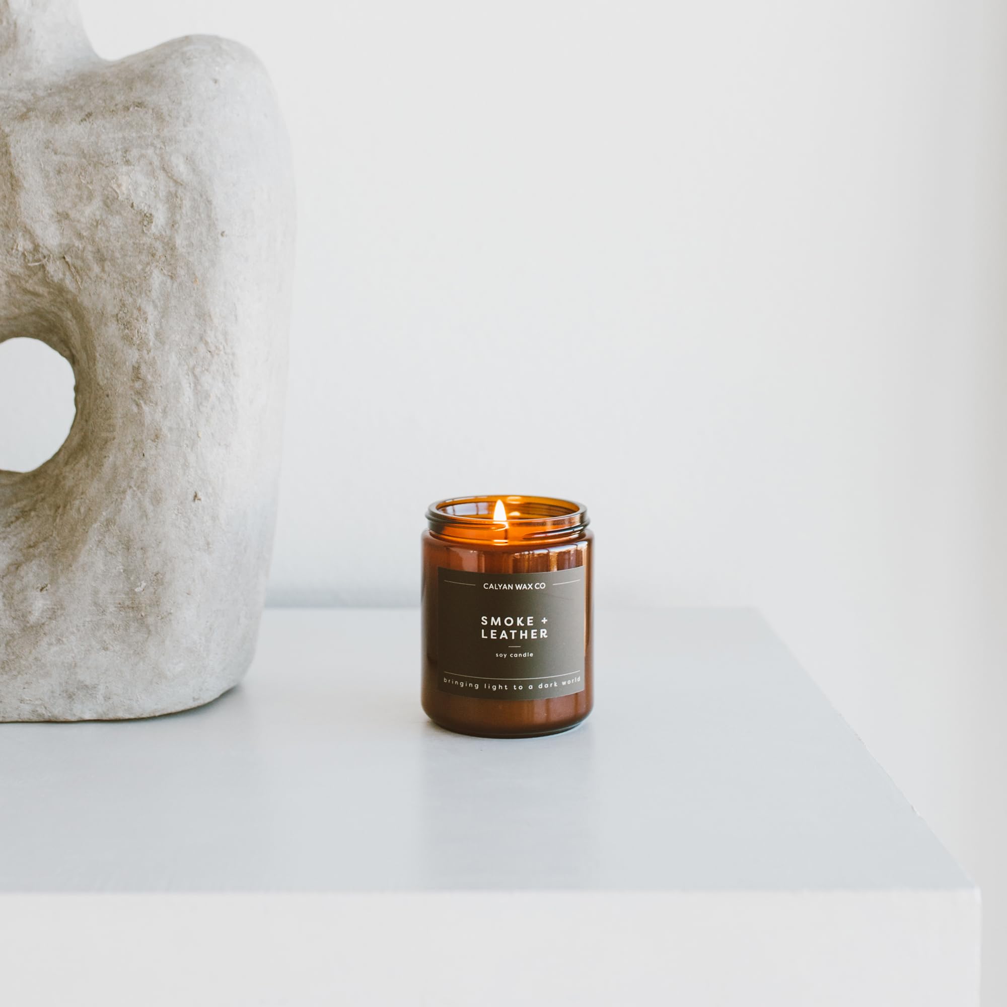 Room scene with amber jar candle as ambient centerpiece.