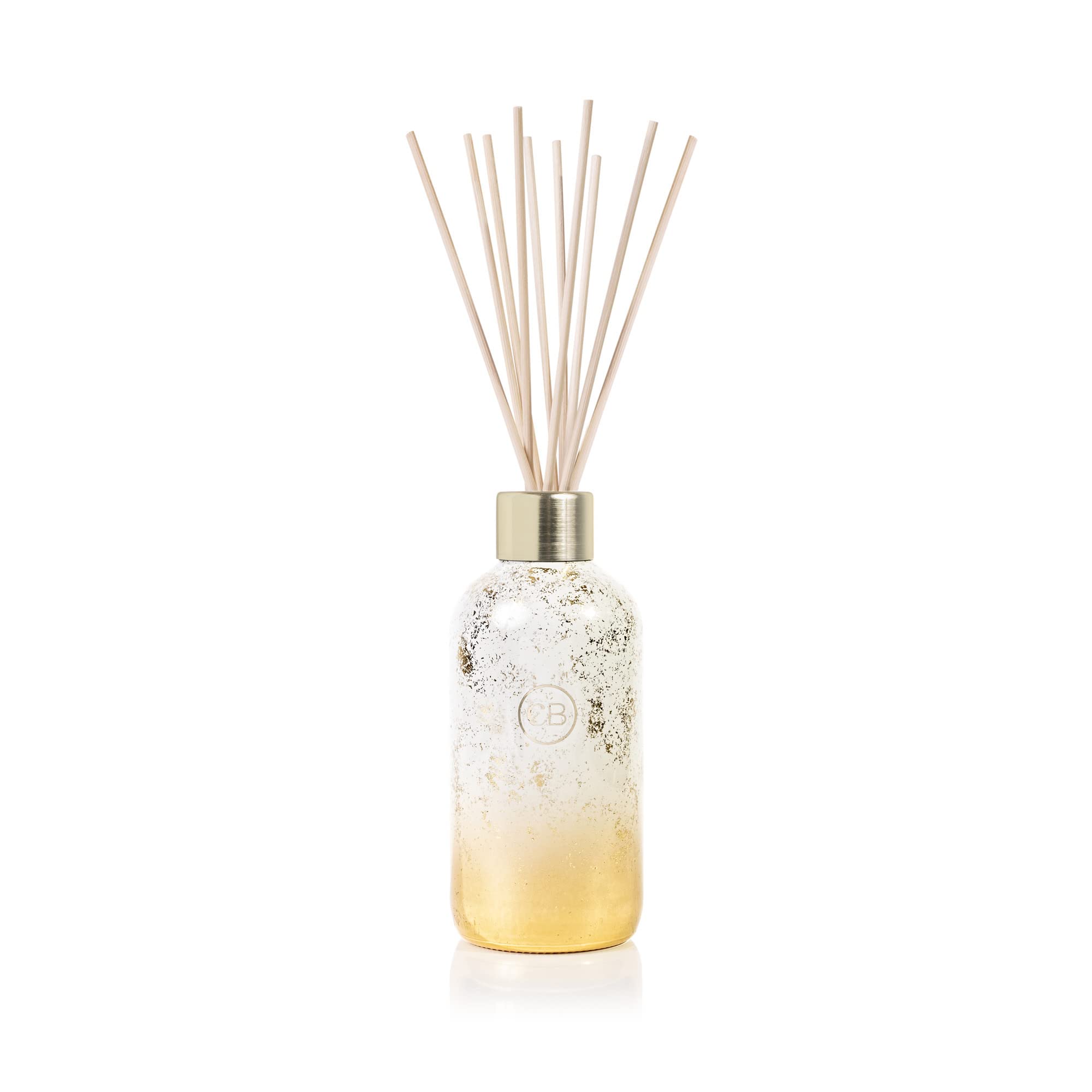 Capri Blue Glimmer volcano diffuser bottle with gold accents enhances festive ambience.