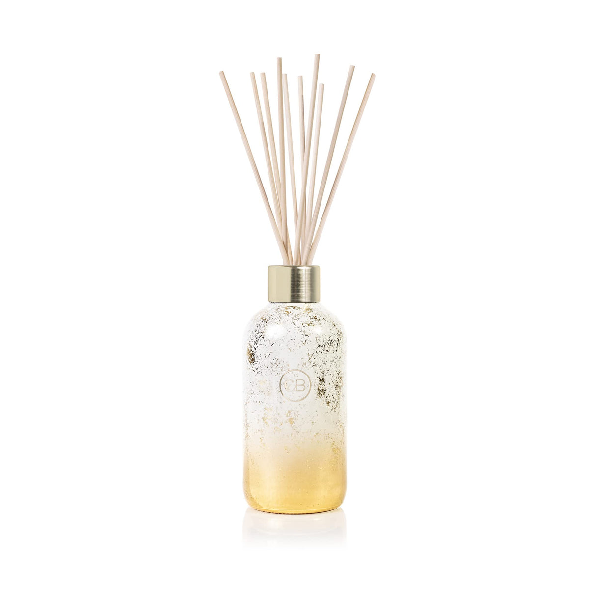 Capri Blue Glimmer volcano diffuser bottle with gold accents enhances festive ambience.