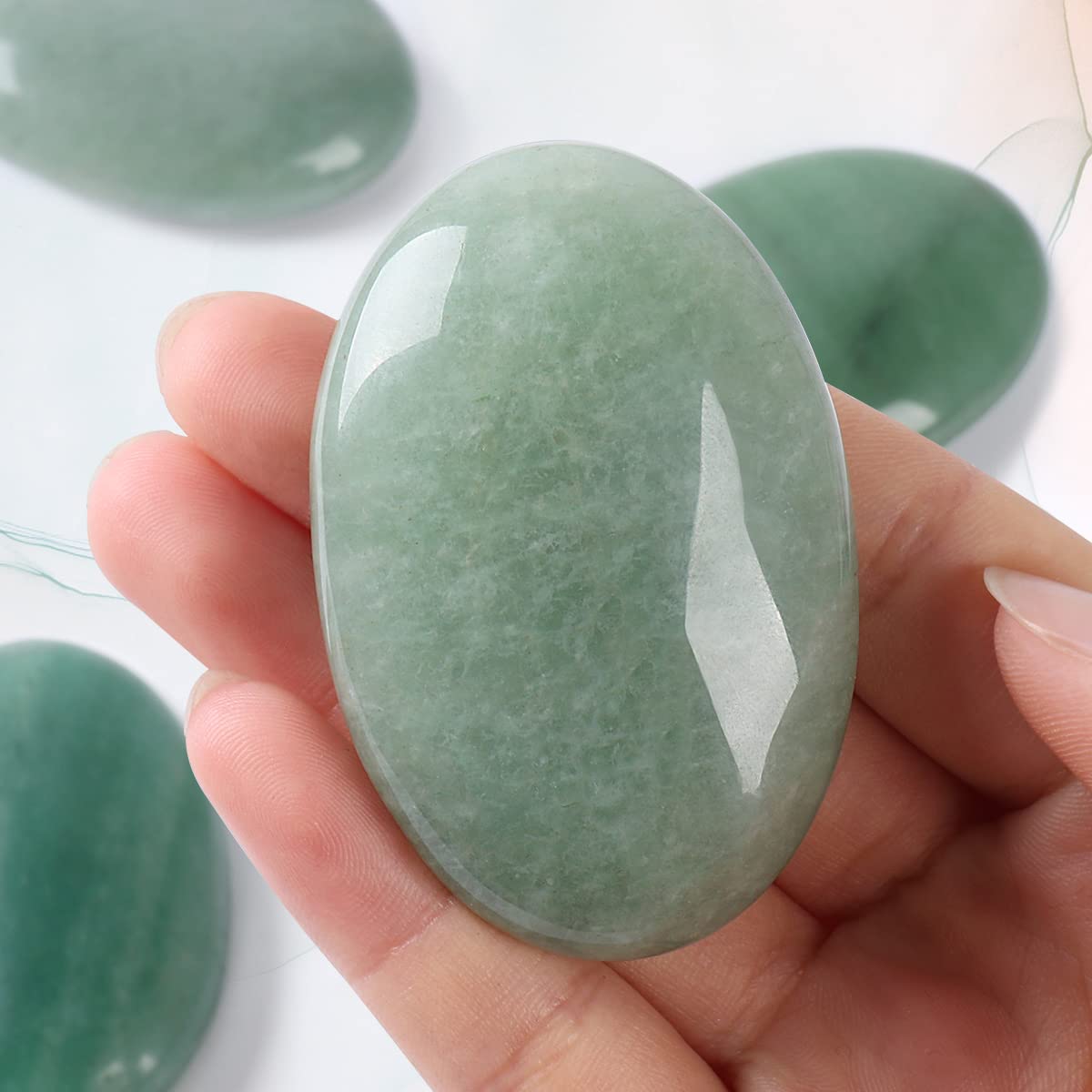 Casmon green aventurine palm stone placed in crystal grid for balance