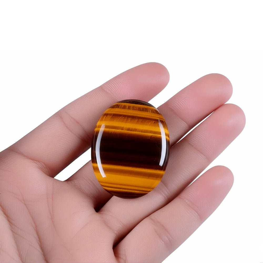 Chiorgone Tiger's Eye thumb stone in hand for grounding during study or work.