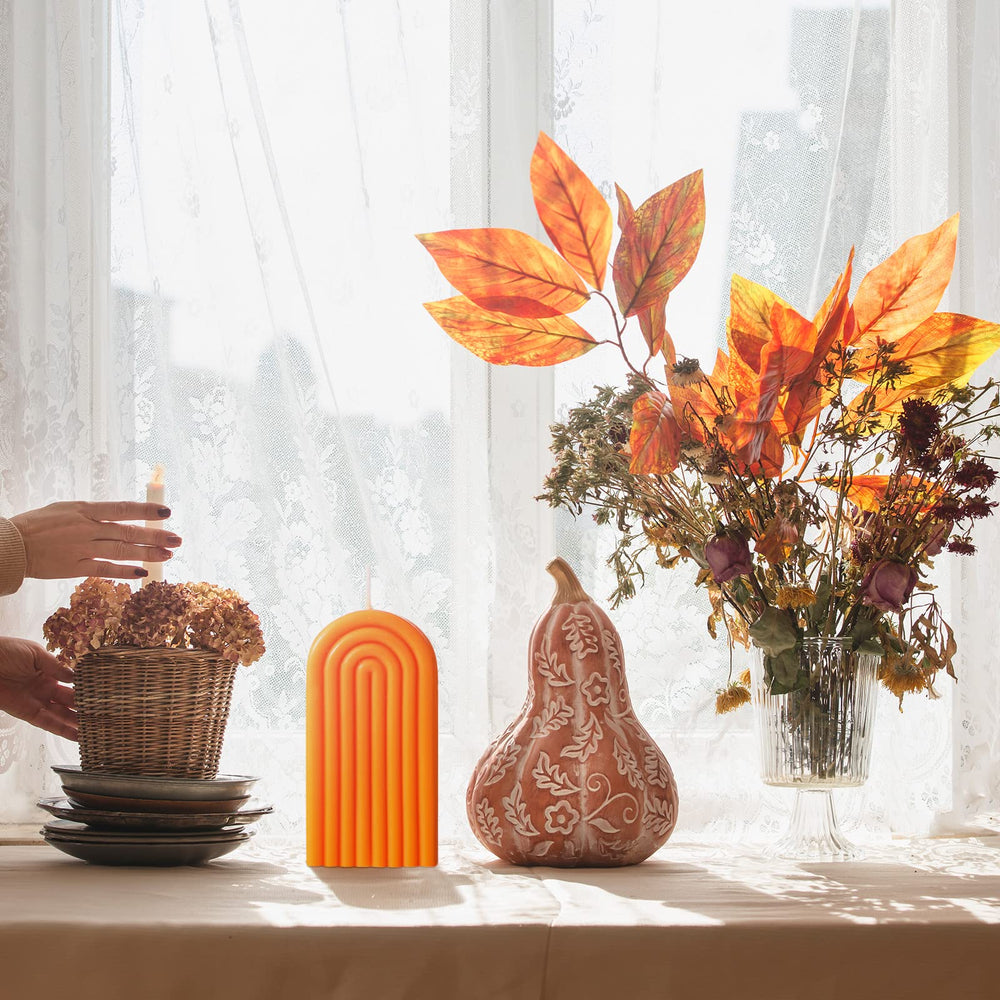 Coume arch candle orange creates a stylish focal point at home.