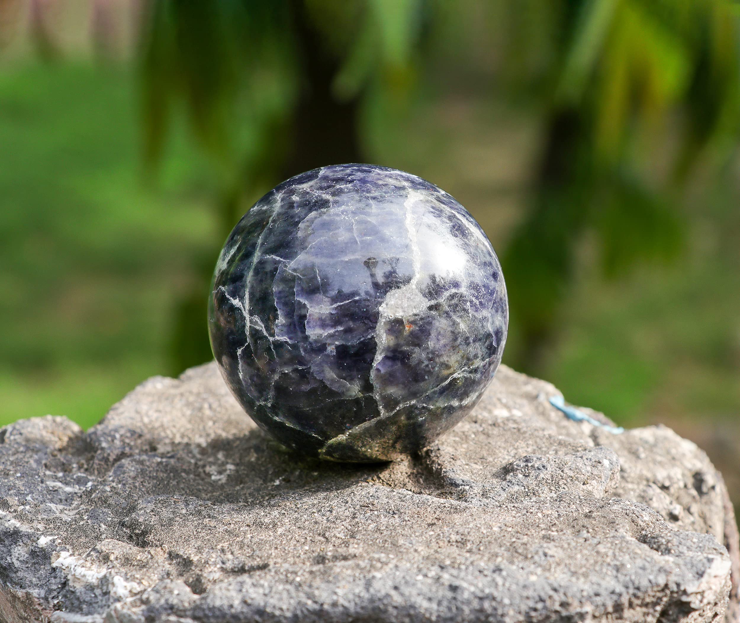 Crocon crystal ball displayed with wooden stand for meditation ambience.