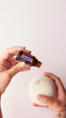 doTERRA Lavender oil bottle beside lavender blossoms for natural relaxation
