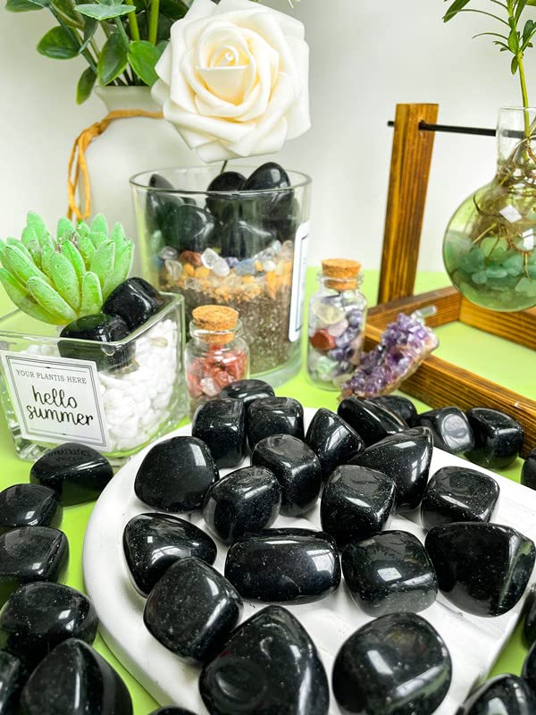 Polished obsidian tumbled stones reflecting sunlight for home decor