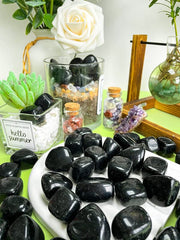 Polished obsidian tumbled stones reflecting sunlight for home decor