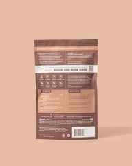 Elements Truffles protein powder scoop poured into a chocolate shake for a chocolatey boost