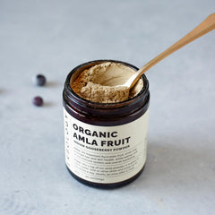 Erbology Amla Powder jar close-up highlighting amber glass and natural texture