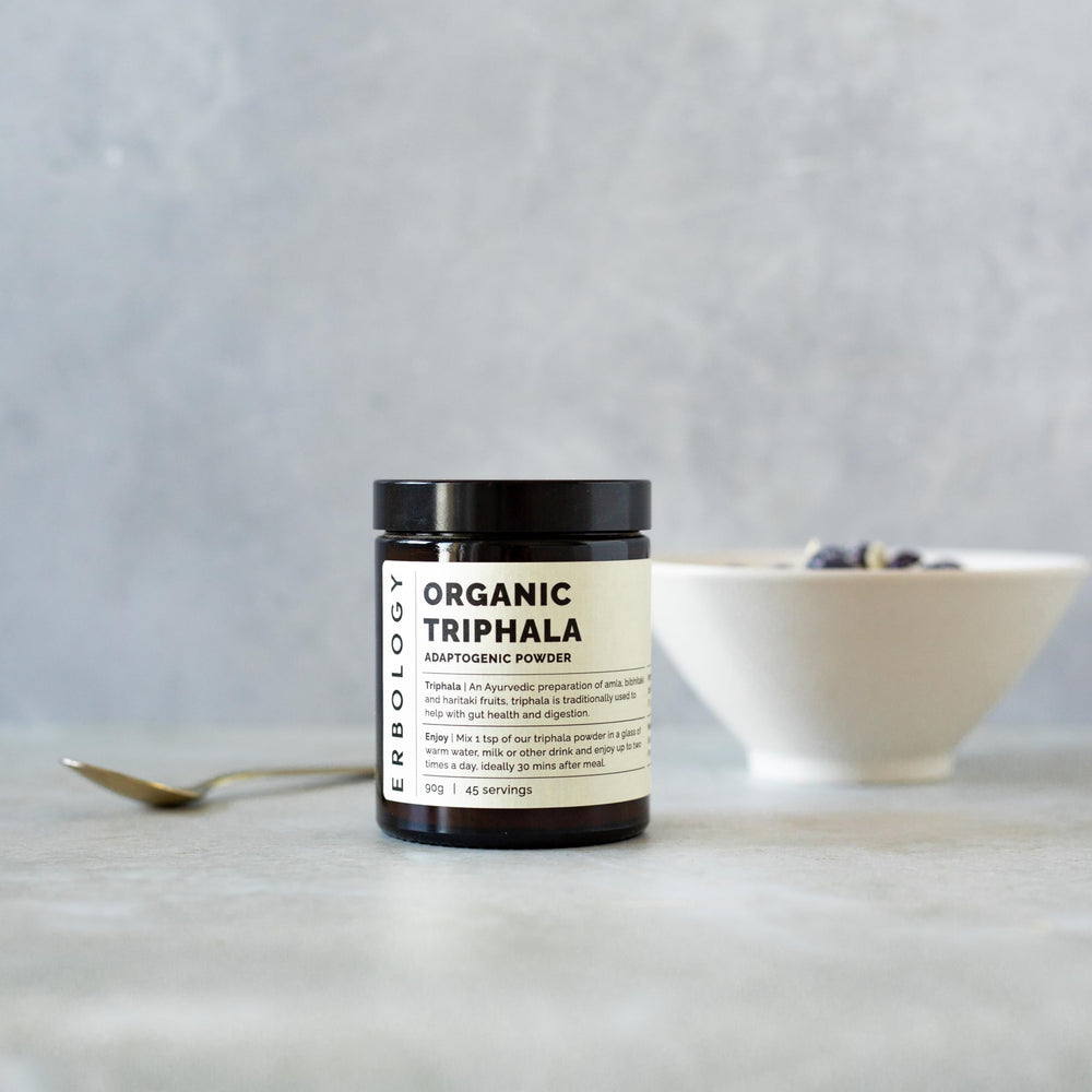 Erbology Triphala powder blend of amla, haritaki, and bibhitaki for daily smoothies.