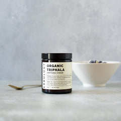Erbology Triphala powder blend of amla, haritaki, and bibhitaki for daily smoothies.
