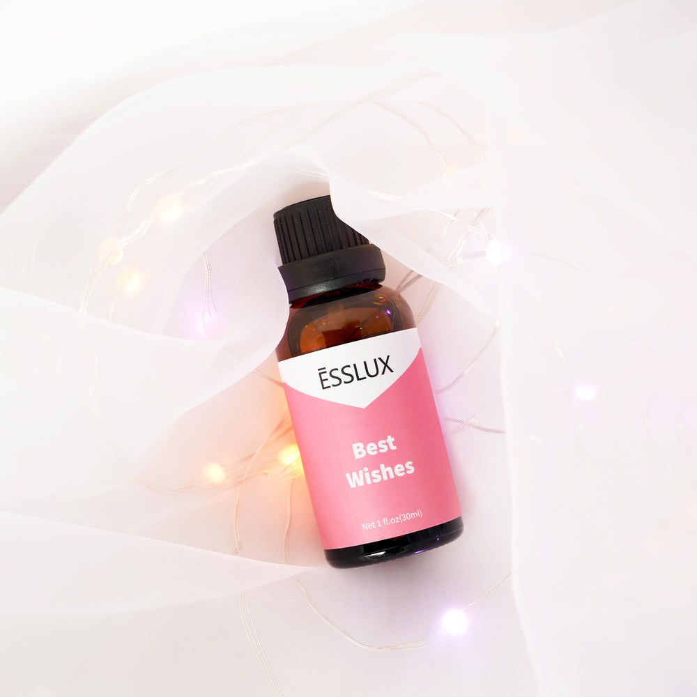 ESSLux Best Wishes Fragrance Oil amber glass bottle on desk with premium packaging.