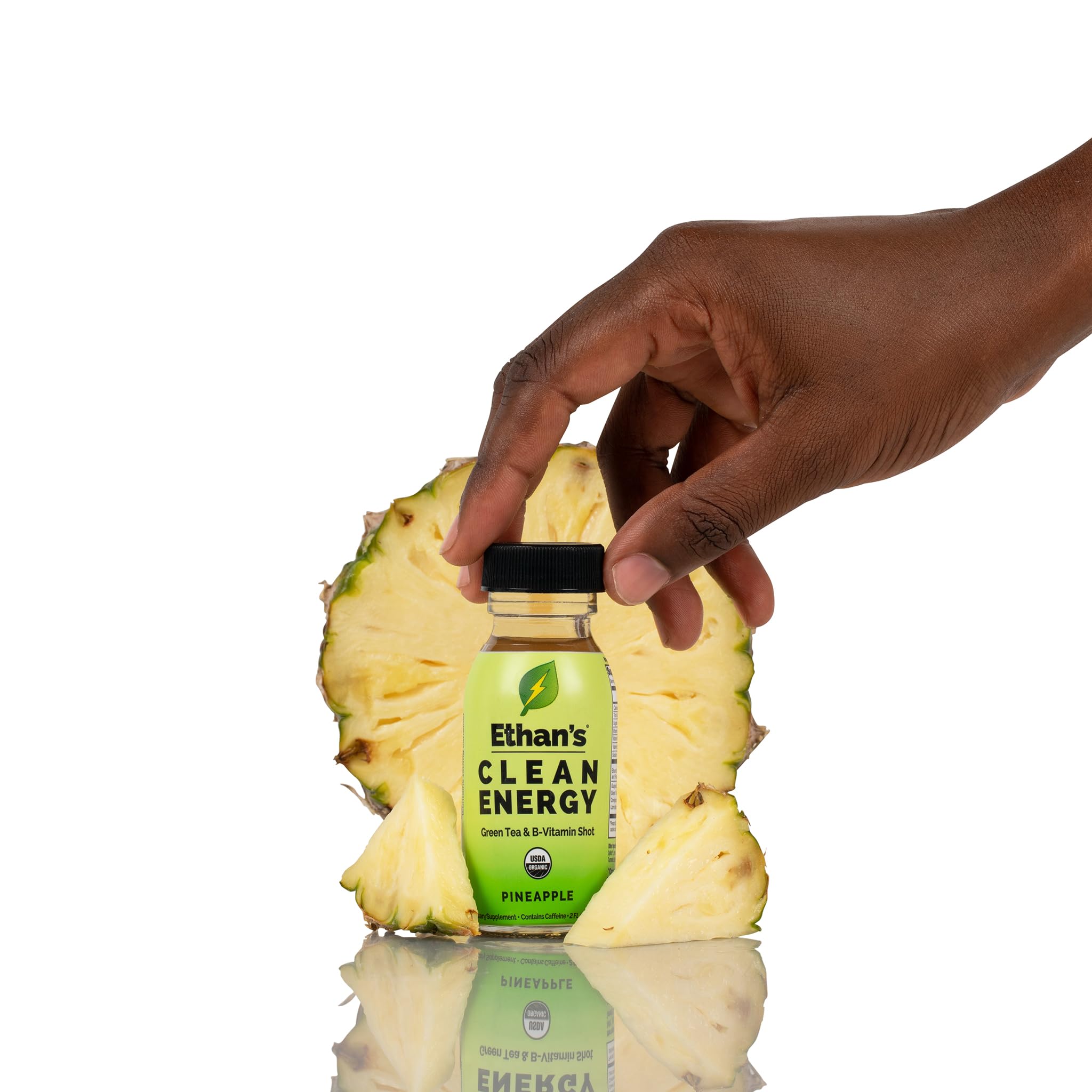 Pineapple flavored energy shot in glass with kitchen counter backdrop.